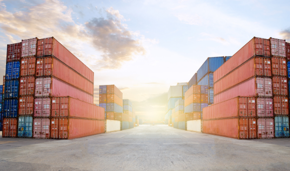 Stock-throughput-Supply-Chain Stacks of shipping containers with sunflare in the background