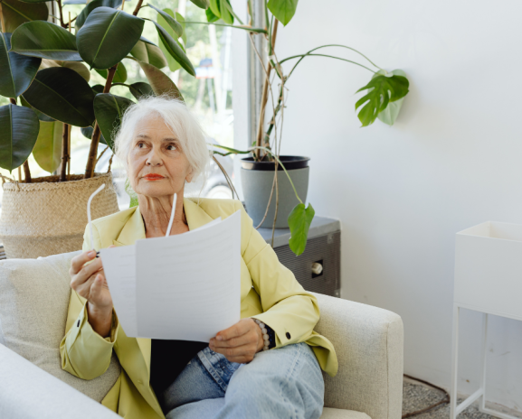 Older adult reviewing prescription drug plan documents at home ahead of Medicare Part D changes in 2027.